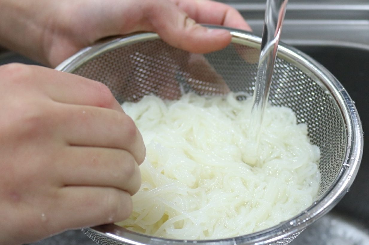 ざるで冷水にさらす白い麺