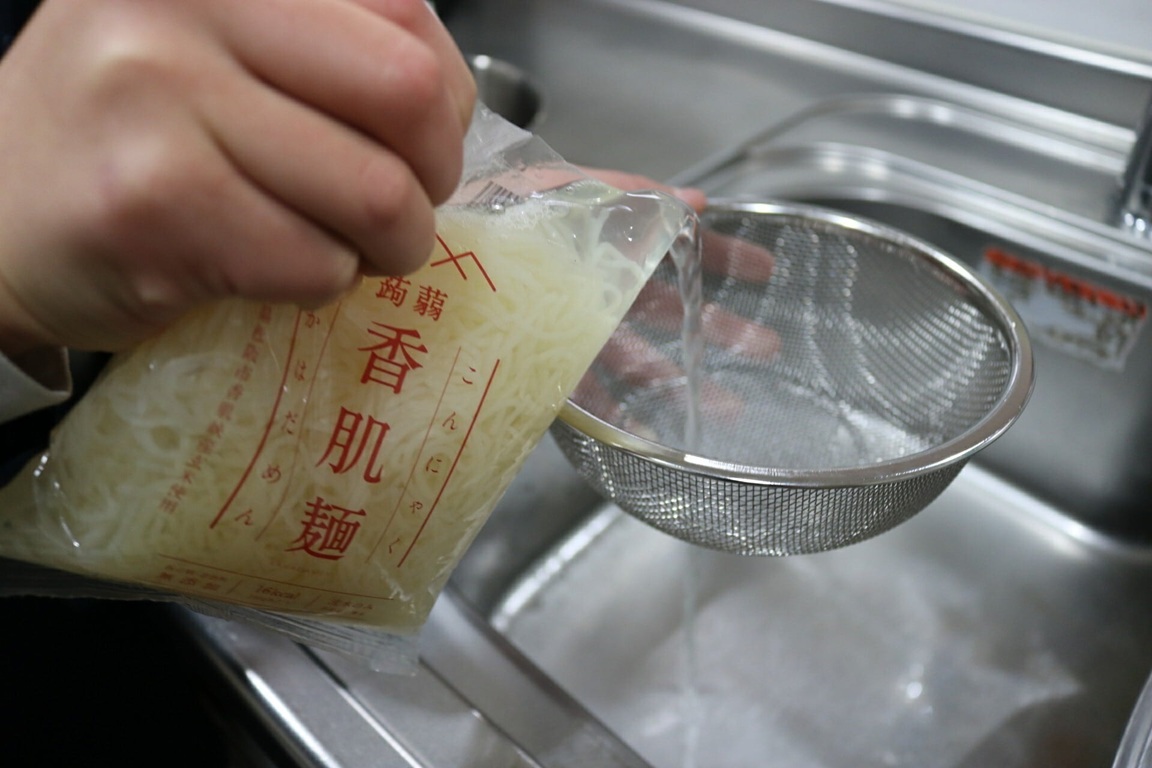 袋から麺を水に移す手元