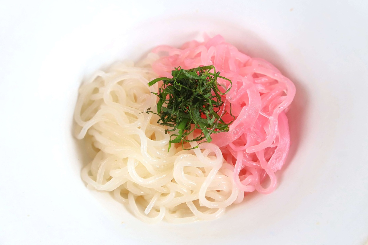 白と薄紅色のそうめんが皿に盛られる