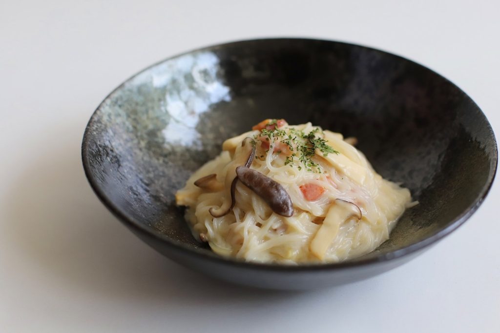 黒いボウルに入ったホワイトパスタ