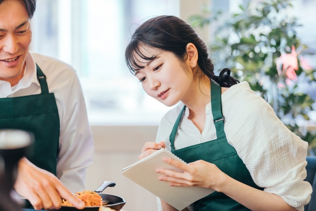 エプロン姿でレシピを確認する女性